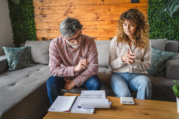 senior man and adult woman calculate household expenses