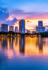 Fototapeta premium View of the city's tall buildings and skyline reflected in the calm water at sunset. high resolution ai generate image
