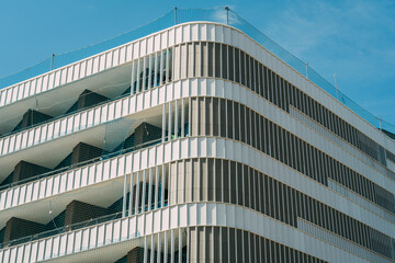 Fototapeta premium Symmetrical Modern Architecture: Building Facade with Balconies under Clear Blue Sky