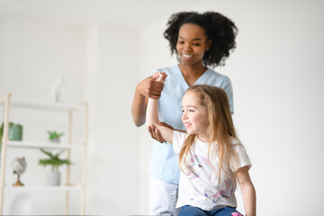 Physiotherapist working with child girl patient in a rehab clinic