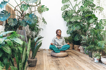 A woman meditates in a calm and serene environment of a green garden