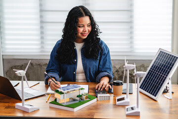 Female architect analyzes energy efficiency by calculating solar panel output, wind turbine...