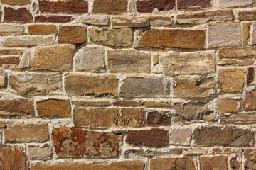 Old brown stone wall showing deterioration and wear from weathering