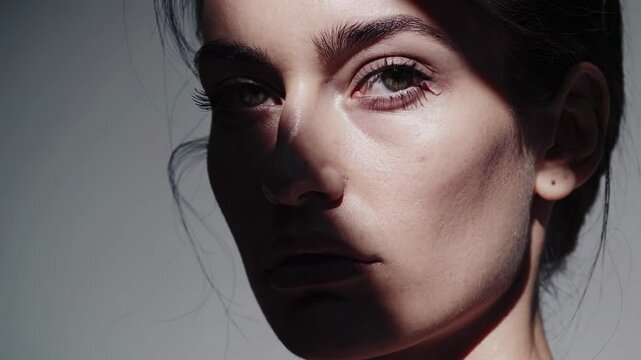 Dramatic play of light and shadow on woman's face capturing intensity and emotion