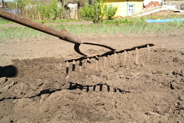 rake against the background of soil, robot in the garden
