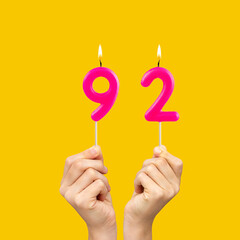 Birthday number 92 - Hands holding fuchsia colored candles
