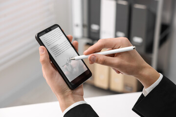 Electronic signature. Man using stylus and smartphone at table indoors, closeup