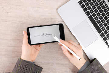 Electronic signature. Woman using stylus and smartphone at wooden table, top view