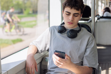 Teenage boy with smartphone looking tired and worried, digital overload and cyberbullying concept,...