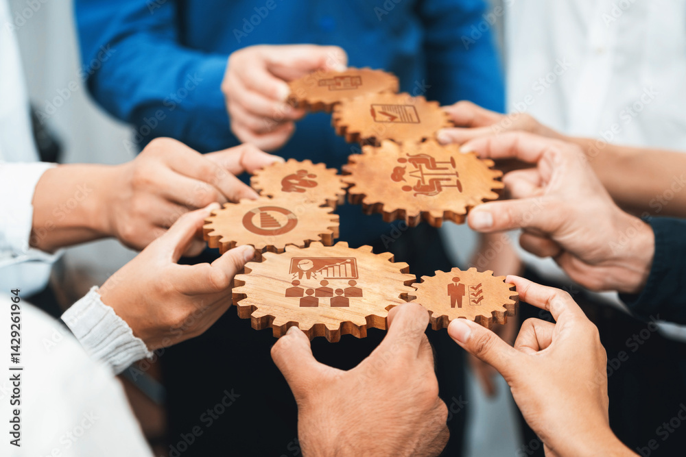Aufkleber A diverse group of hands holds wooden gears, each representing different aspects of teamwork and management in a vibrant business setting, symbolizing unity and shared goals. Amity