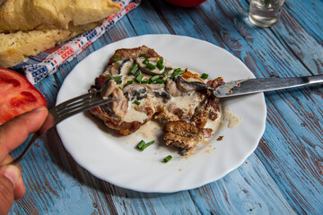 Pan seared pork steak on a wooden table with white sauce,pork fillet with dressing..