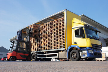 Counterbalance driver unloading lorry fully loaded with euro pallets.
