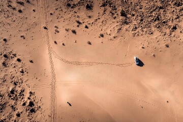 Desert Landscape with Car Tracks and Footprints Under Clear Sky