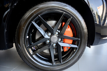 Car wheel with brake calipers and stylish design.