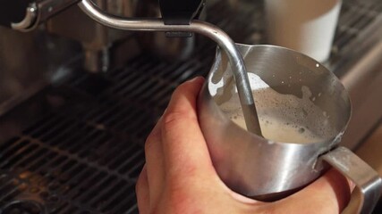 The barista skillfully steams milk for a perfect cappuccino