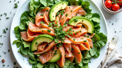 Keto-friendly nicoise salad with avocado, tomato, lettuce, capers, and seared salmon on white plate with fork.