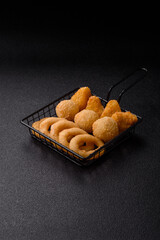 Food, chicken nuggets, onion rings and cheese balls on dark background
