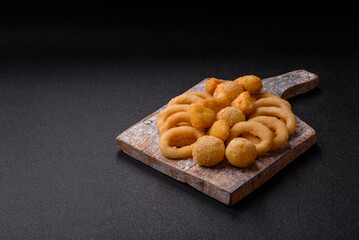 Food, chicken nuggets, onion rings and cheese balls on dark background