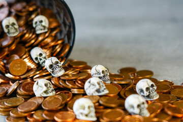 Concept of the tragedy of hoarding money and wealth, skulls on a pile of spilled money