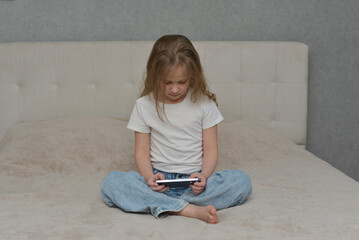 Focused Young Girl Using Smartphone on Bed