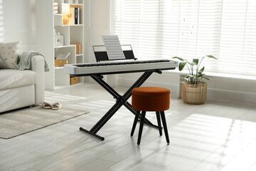 Synthesizer with music sheet and pouf at home