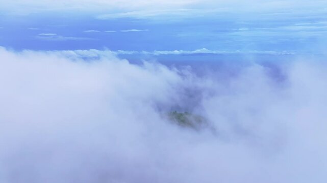 Soft clouds cover peaks of Koh Phi Phi from sky, Thailand. Aerial drone video