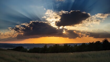 Obraz premium dark dramatic sky at sunset with sun rays through the clouds