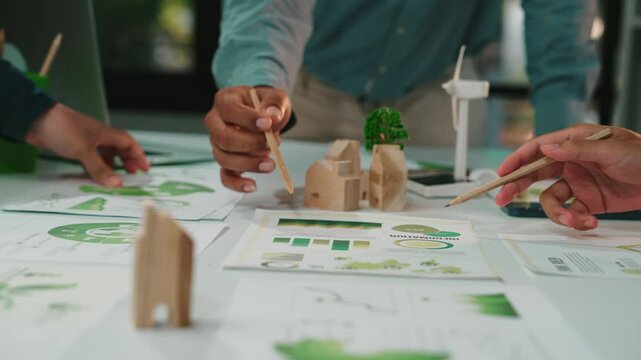 A diverse team collaborates on a sustainable project, showcasing charts and eco-friendly materials in a bright office. Focus on teamwork and innovation. SACTR