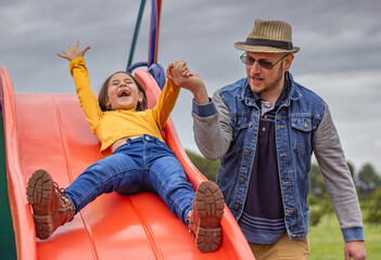 father-helping-daughter-on-slide