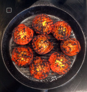 Overhead view of Grilled tomatoes cooking in a griddle pan