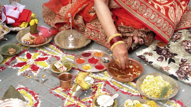 A close up of a traditional nepali ceremony with a person hand worship money with red tika .