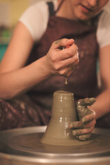 Pottery artist making a shape from clay. Shallow DOF. Developed from RAW; retouched with special care and attention; Small amount of grain added for best final impression. 