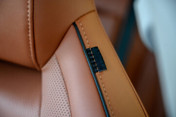 Interior view of a car showcasing brown leather seats with black seat belts.