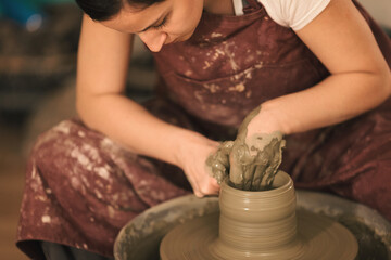 Pottery artist making a shape from clay. Shallow DOF. Developed from RAW; retouched with special care and attention; Small amount of grain added for best final impression. 