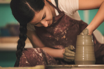Pottery artist making a shape from clay. Shallow DOF. Developed from RAW; retouched with special care and attention; Small amount of grain added for best final impression. 