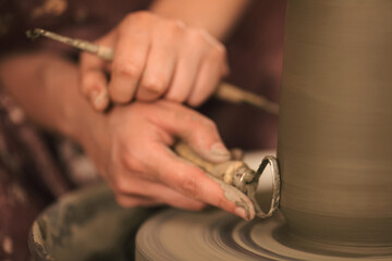 Pottery artist making a shape from clay. Shallow DOF. Developed from RAW; retouched with special care and attention; Small amount of grain added for best final impression. 