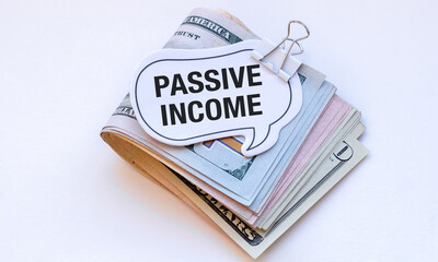 A stack of money with a sign that says Passive Income on top