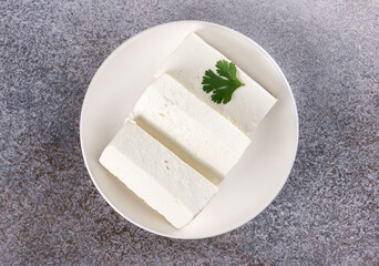Indian paneer cheese made from fresh milk and lemon juice on grey background. Top view