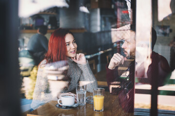 Young beautiful couple at coffee shop talking