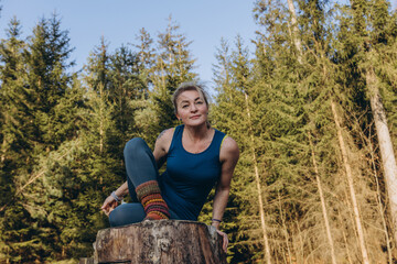 Fit sporty happy young woman wearing sportswear meditating doing yoga breathing stretching...