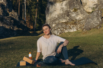 Young woman practicing yoga on nature. Girl meditating outdoors. Female with slim, strength and...