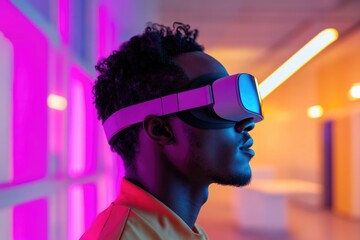 A young man with curly hair experiences virtual reality in a vibrant neon-lit room.