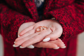 bride holding wedding rings in hands, young caucasian woman, close-up view of hands, love and...