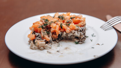 half-eaten salad with carrots and meat on white plate