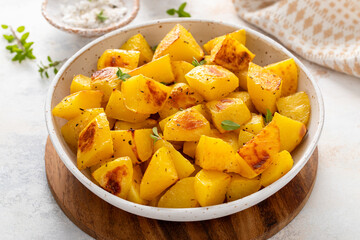 Oven roasted potatoes in a serving bowl cooked with herbs and spices