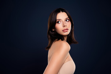 Naklejka premium Portrait of a stylish young woman with natural beauty posing against a dark blue background for fashion and skincare