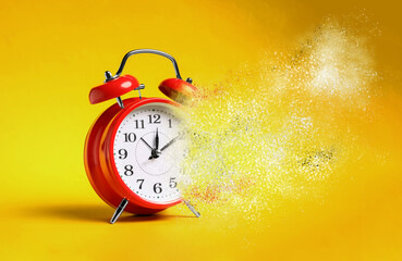 Alarm clock dissolving on orange background. Time is running out