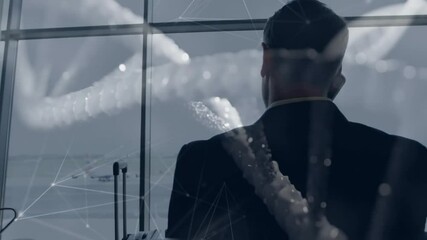 Businessman standing at airport gate, speaking on smartphone, featuring travel data network overlay - Powered by Adobe