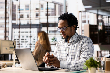 Successful entrepreneur working on financial forecasts at his desk, using data and technology to...