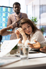 Female general manager trying to handle the organizational crisis during a meeting with staff,...